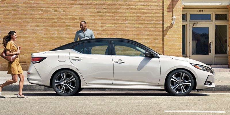 Nissan of Lexington Park in California MD Nissan Sentra side view in white parked in front of a brick building