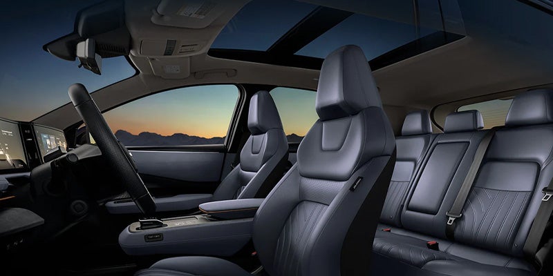 Nissan ARIYA parked on dusky terrain with mountains in the background