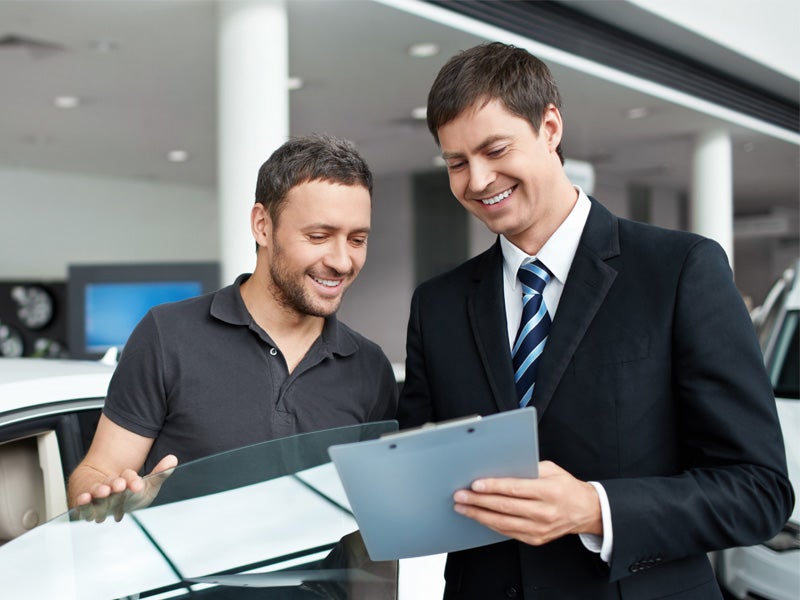 Nissan of Lexington Park in California MD sales rep going over paperwork with customer