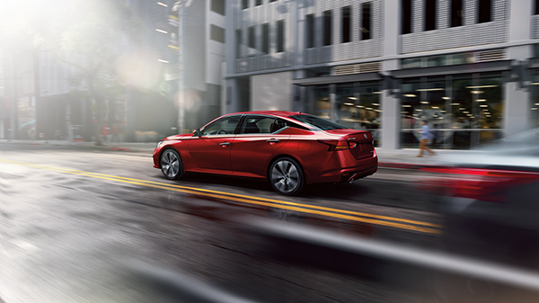 Nissan of Lexington Park in California MD red Nissan driving in the city after a rainstorm