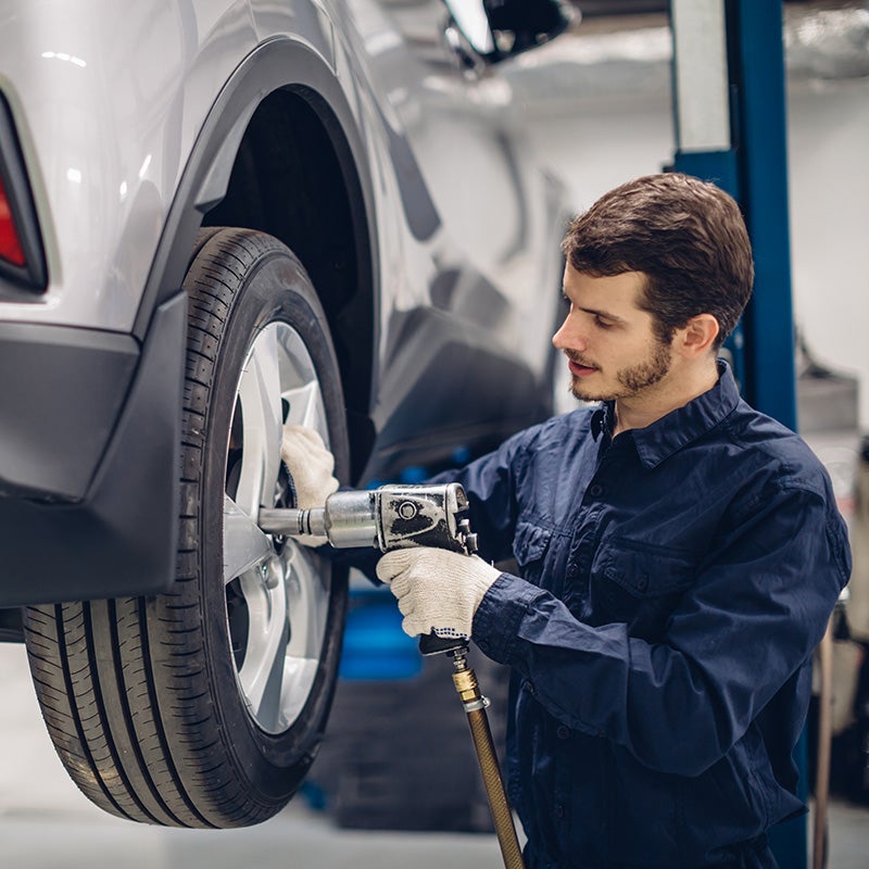 Nissan of Lexington Park in California MD service technician changing a tire